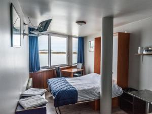 Cette chambre comprend un lit, un bureau et une fenêtre. dans l'établissement La maison du Lenn face à la mer, à Louannec