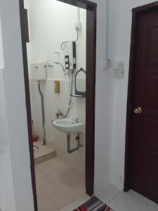 La salle de bains est pourvue d'un lavabo et d'une douche. dans l'établissement DIAMOND HOMESTAY, à Kuala Kangsar