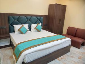 - une chambre avec un grand lit et un canapé dans l'établissement Amigo Rooms, à Rishikesh