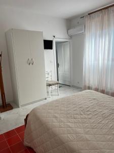 アジェーロラにあるPiccolo Sognoの白いベッドルーム(ベッド1台、キャビネット付)