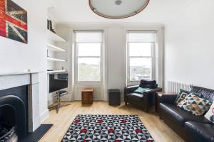 GuestReady - Beautiful Home in Wimbledon Village في لندن: غرفة معيشة مع أريكة ومدفأة