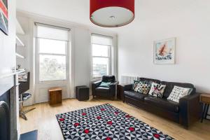 ein Wohnzimmer mit einem Sofa und einem Teppich in der Unterkunft GuestReady - Beautiful Home in Wimbledon Village in London