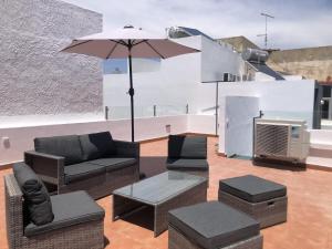 a living room with furniture and an umbrella and a tv at Casa Fernanda in Fuzeta