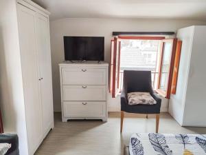 ein Schlafzimmer mit einer Kommode mit einem TV und einem Stuhl in der Unterkunft Mansarda Balilla Centralissima vicinissima al mare in San Benedetto del Tronto