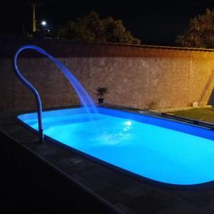 a blue swimming pool with a water fountain at Studio Mar & Sol in Armacao dos Buzios