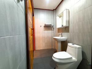 een badkamer met een wit toilet en een wastafel bij Isaan Perazim Park in Roi Et