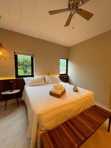 een slaapkamer met een groot bed en een plafondventilator bij Pousada Yamandu in Juquei