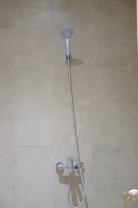 a shower with a shower head in a bathroom at Tadaima Suites Cilegon in Cilegon