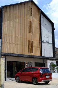 a red car parked in front of a building at Tadaima Suites Cilegon in Cilegon