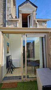 a sliding glass door of a patio with a table and chairs at Maison Bretagne in Saint-Jacut-de-la-Mer