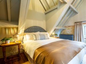 een slaapkamer met een groot bed in een kamer bij The Barns at Stoneythorpe in Southam