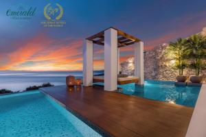 a luxury villa with a infinity pool at sunset at Emerald Villas & Suites - The Finest Hotels Of The World in Agios Nikolaos