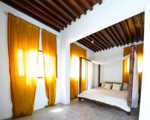 a bedroom with a bed with orange drapes at Salaam Space in Muscat