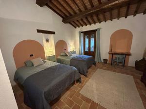 a bedroom with two beds and a table in it at Villa Convento Pietralunga in Pietralunga +47 photos