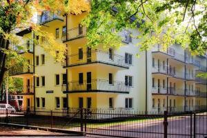 duży żółty budynek z balkonami na boku w obiekcie Apartment in Mi dzyzdroje near Sandy Beach w mieście Międzyzdroje