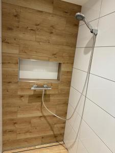 a shower in a bathroom with a wooden wall at City-See Central Apartment in Marl +21 photos