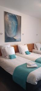 阿普勒蒙的住宿－聖文森特酒店，墙上画画的房间的三张床