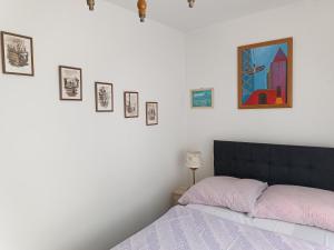 sypialnia z łóżkiem i obrazami na ścianie w obiekcie Pension U Stašáků w mieście Jetřichovice