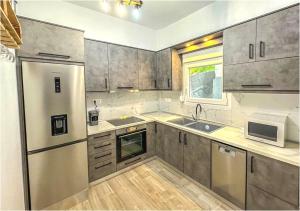 a kitchen with wooden floors and stainless steel appliances at PANGEA in Limenaria