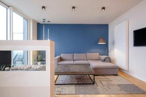 ブリュッセルにあるBeautiful 1 bedroom apartment close to Parc de Bruxellesの青い壁のリビングルーム(ソファ付)
