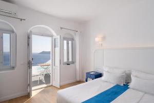 a bedroom with a bed and a view of the ocean at Katikies Villa Santorini - The Leading Hotels Of The World in Oia