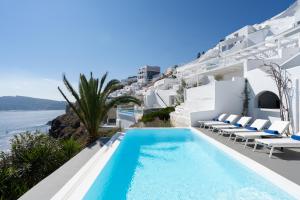 a pool on the side of a villa with white at Katikies Villa Santorini - The Leading Hotels Of The World in Oia
