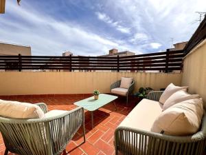 um pátio com 2 cadeiras e uma mesa no telhado em House with terrace connected with Downtown&Airport em Barcelona