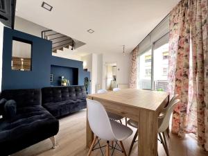 uma sala de estar com uma mesa de madeira e um sofá em House with terrace connected with Downtown&Airport em Barcelona