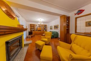 un soggiorno con mobili gialli e camino di La Terrazza sui Monti a Castiglione dʼIntelvi