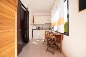 a small kitchen with a wooden table and a small table and chairs at Monolocale Free Beach Residence due passi dal mare in Costa Rei
