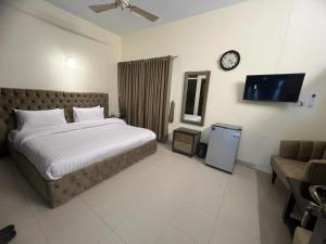 um quarto com uma cama e um relógio na parede em Cozy Cottage Islamabad em Islamabad