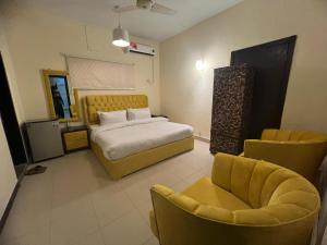 イスラマバードにあるCozy Cottage Islamabadのベッドルーム(ベッド1台、ソファ、椅子付)