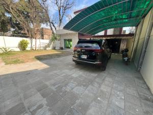 um carro estacionado fora de uma casa com uma garagem em Cozy Cottage Islamabad em Islamabad