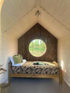 a bed in a small room with a window at Sugi wooden pod in York +26 photos