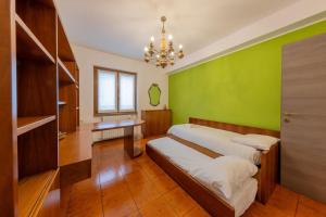 una camera con due letti e una parete verde di La Terrazza sui Monti a Castiglione dʼIntelvi