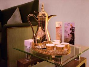 a glass table with a tea kettle and candles on it at OYO 367 Eureka Hotel in Dubai