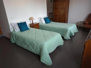 2 Betten in einem Hotelzimmer mit blauen Kissen in der Unterkunft Valentim House in Viana do Castelo