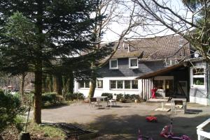 a large white house with a patio and a yard at Hotel am See Radevormwald in Radevormwald