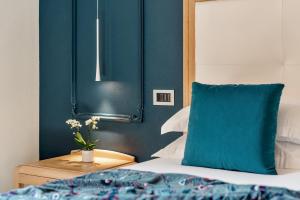 una camera da letto con pareti blu e un letto con un cuscino blu di Park Hotel Argento a Levanto