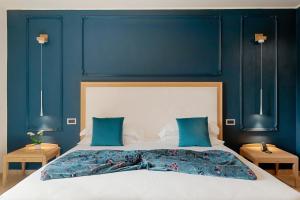 レヴァントにあるパーク ホテル アルジェントの青い壁のベッドルーム1室(大型ベッド1台付)