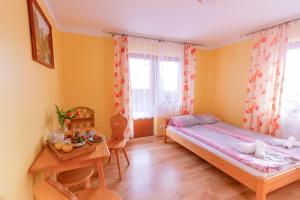 a small bedroom with a bed and a table at Willa Piękne Widoki in Ząb