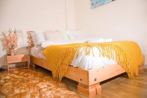 a bedroom with a bed with a yellow blanket on it at Adeti Homestay in Ruiru