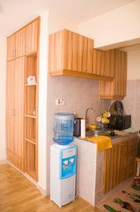 uma cozinha com um tanque de água em cima de um frigorífico em Adeti Homestay em Ruiru