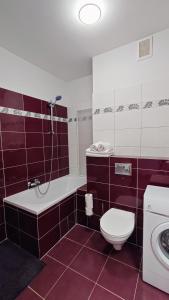 a bathroom with a tub and a toilet and a sink at Apartament Modern Life w centrum z parkingiem in Jelenia Góra