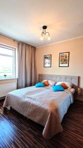 a bedroom with a large bed with blue pillows at Apartament Modern Life w centrum z parkingiem in Jelenia Góra