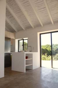 cocina con encimera blanca y ventana grande en Beautiful country home immersed in nature, en São Teotónio