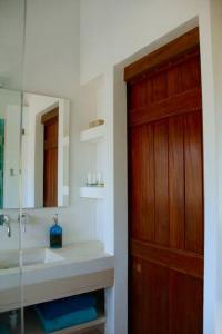 baño con lavabo y puerta de madera en Beautiful country home immersed in nature, en São Teotónio