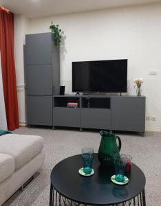 sala de estar con TV y mesa de centro en Apartman Sunset, en Osijek