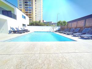 einen Pool mit Liegestühlen und ein Gebäude in der Unterkunft Casa do Salgueiral Douro in Peso da Régua