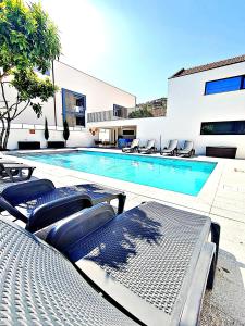 a swimming pool with lounge chairs next to a building at Casa do Salgueiral Douro in Peso da Régua
